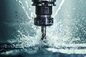 CNC-maskine i drift med kølevæske, der sprøjter under præcis metalbearbejdning.