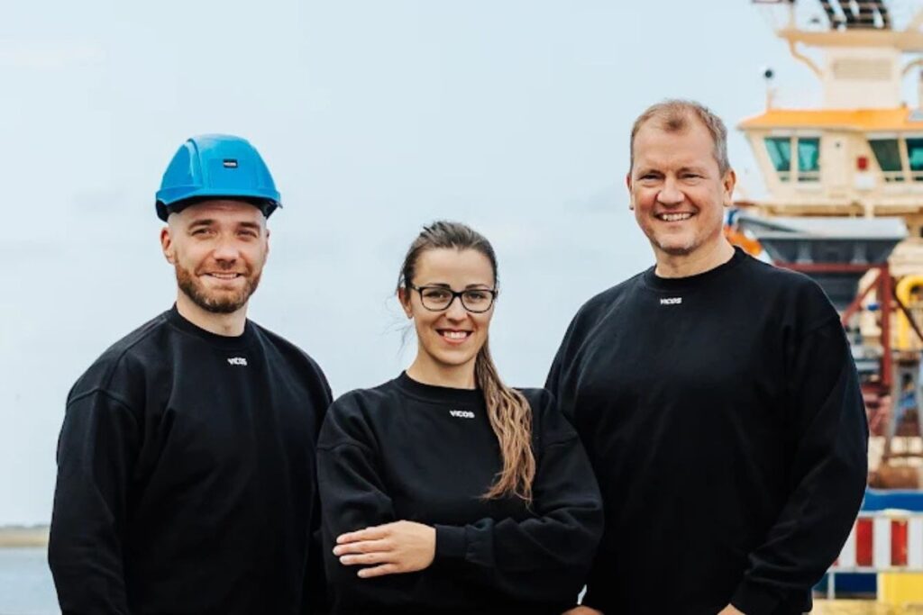 Tre medarbejdere fra VICOS stående i industrielt miljø og repræsenterer bemanding, samarbejde og mandskabsudlejning.