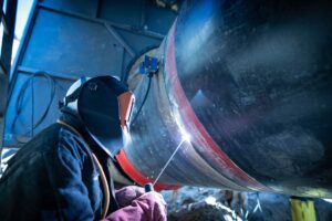 Svejser ved rørsvejsning i industrien som illustration til udenlandsk arbejdskraft i Danmark